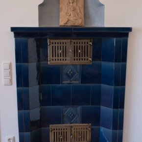Kachelofen und Kopie des Reliefs der Fuggersäule